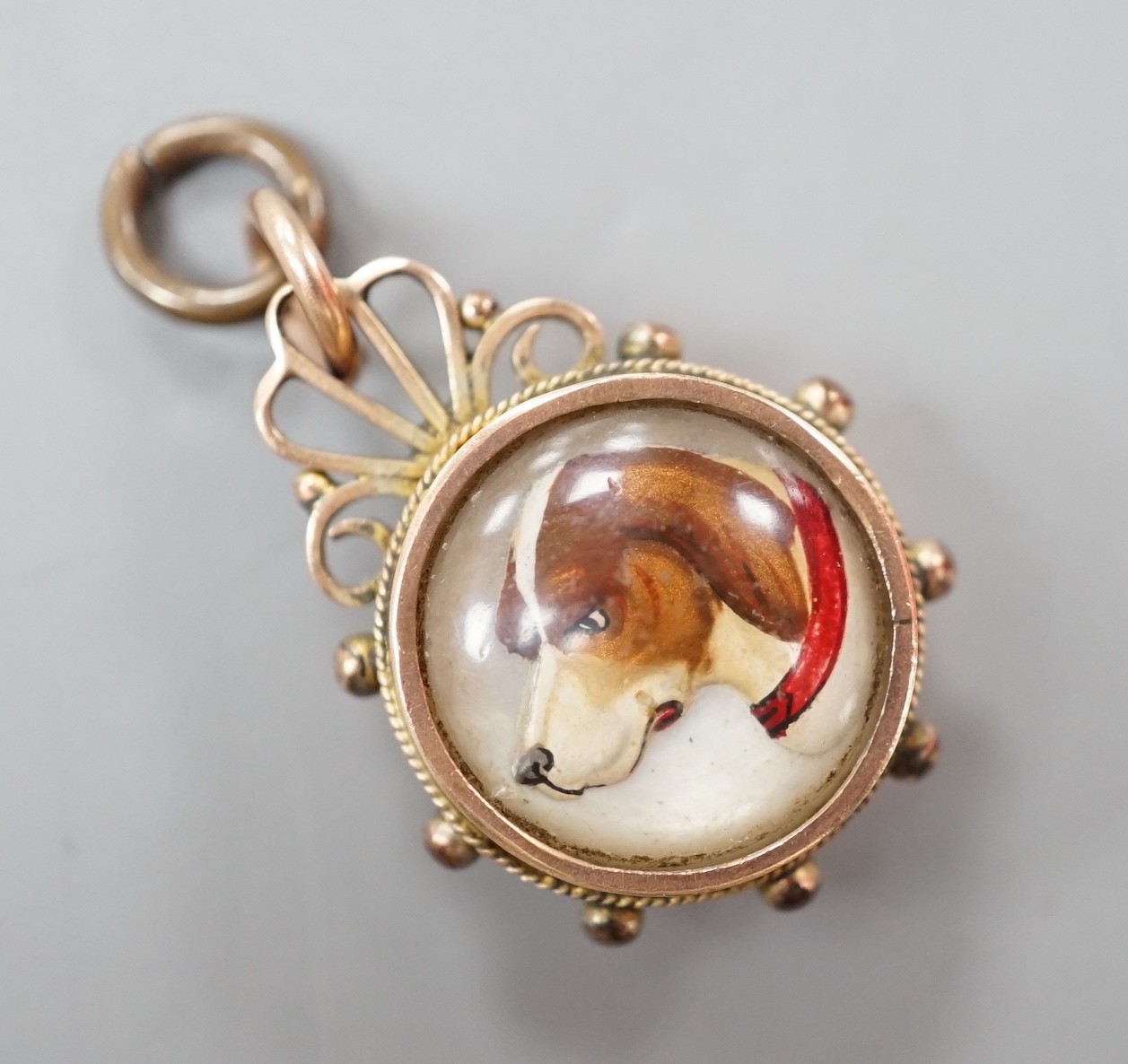 A late Victorian 9ct gold mounted Essex crystal and compass set fob, 25mm, the crystal decorated with the head of a dog.